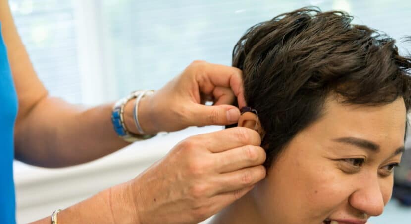 DWM patient getting fitted with a hearing aid