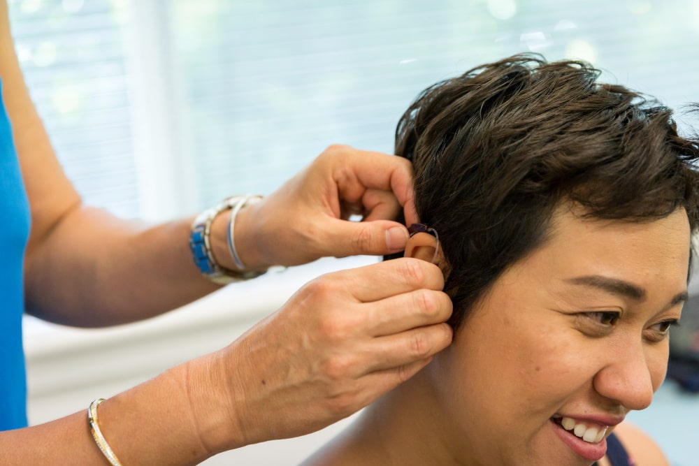 DWM patient getting fitted with a hearing aid